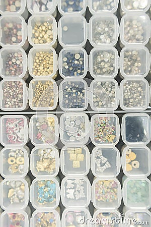 Various nail art beads, gemstones and accessories neatly organized in clear containers Stock Photo