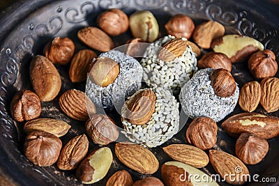 Various nuts are laid out in a brown handmade clay plate Stock Photo