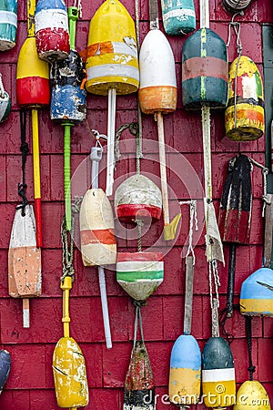Various onboard used floats for mooring boats and schooners are decoratively hung on the wall of the building Stock Photo