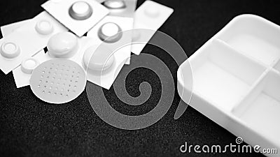 Various pills in blisters, a round plaster and a pill tray seen in macro Stock Photo