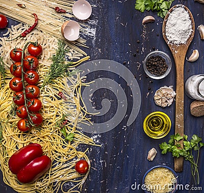 Various raw pasta with vegetables and spices, flour and wooden spoon frame with text area wooden rustic background top view Stock Photo