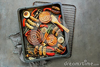 Various roasted sausages and vegetables Stock Photo