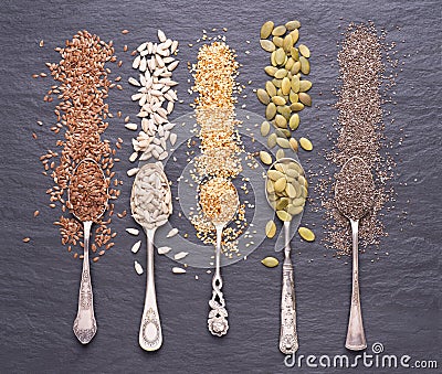 Various seeds - sesame, flax seed, sunflower seeds, pumpkin seed, chia in spoons on stone background. Top view Stock Photo