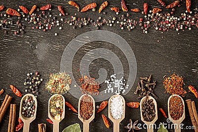 Various spices in wooden spoons on dark wooden table. Stock Photo