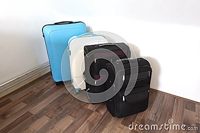 Various suitcases or travel bags in a row near white wall, modern luggage bags for tourism Stock Photo