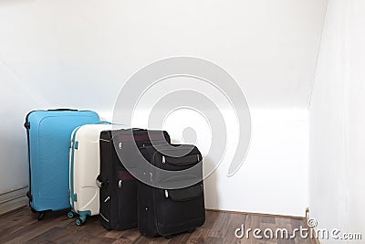 Various suitcases or travel bags in a row near white wall, modern luggage bags for tourism Stock Photo