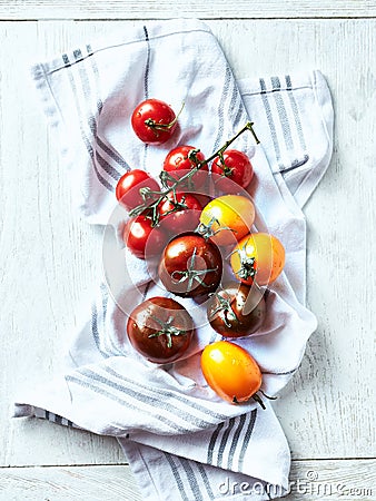 Various summer tomatoes on a kitchen towel. Top view Stock Photo