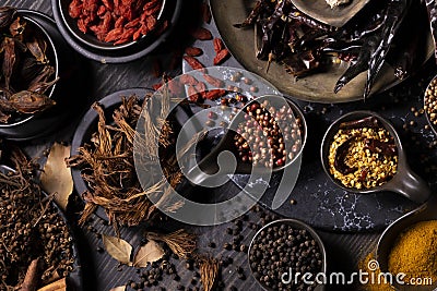 Various type of oriental earthy flavor dry spices on dark wooden table such as turmeric, black pepper, chili flake, bay leaf, for Stock Photo