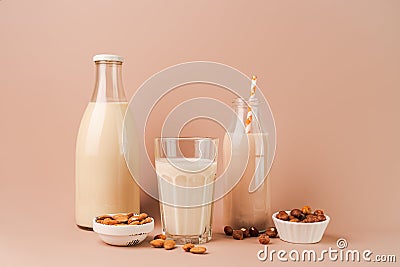 Various vegan plant based milk and ingredients. Dairy free milk substitute drinks on pink background Stock Photo