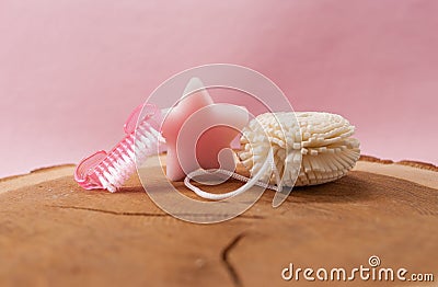various wellness items on a wooden disc, against a pink background. Stock Photo