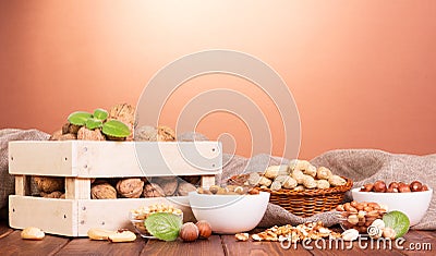 Various whole and peeled nuts on brown background. Stock Photo