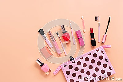 Various women`s makeup cosmetics on a soft pink background. Cosmetic bag, blusher, mascara, lipstick, nail polish and brushes. To Stock Photo