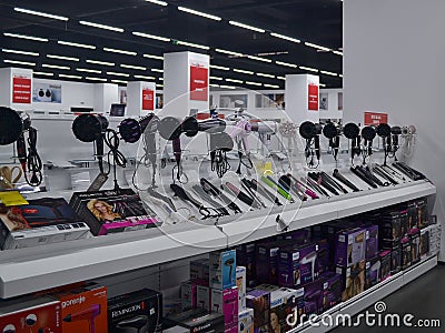 Counter with hairdryers and curling irons of different manufacturers in a Technomarket store in Varna Editorial Stock Photo