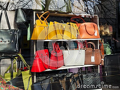 Modern fashionable yellow, red, white and brown leather handbags in a window of a haberdashery shop on a sunny spring day Editorial Stock Photo