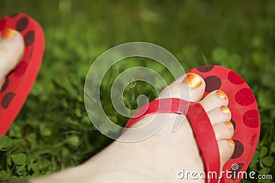 Toes with painted toenails and colorful flip flops Stock Photo