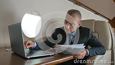 Varón hermoso con el macbook que practica surf en interior de Internet del interior de lujo del jet privado Varón hermoso con el macbook que practica surf en interior de Internet del interior de lujo del jet privado