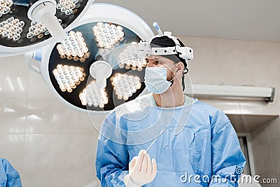 Vascular surgeon is holding EVLT Red laser optical fiber for endovenous laser coagulation for treatment varicose veins Stock Photo