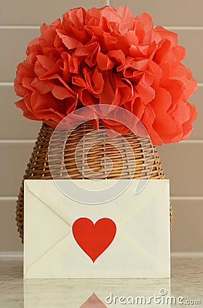Vase basket with red tissue paper flower on kitchen counter top Stock Photo