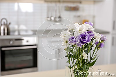 Vase with beautiful flowers in kitchen interior. Stock Photo