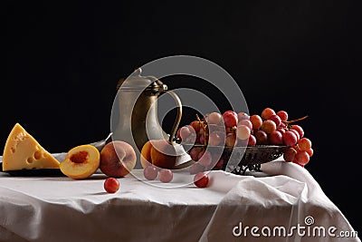 A vase of grapes, peaches, cheese and an old pitcher Stock Photo