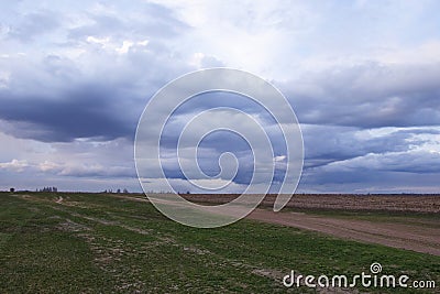 A vast field under a cloudy sky at dusk Stock Photo