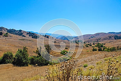 Vast mountain landscape with green trees, blue sky, and clouds at Chino Hills State Park Stock Photo