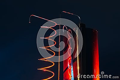 Vat and metallic spiral of alcohol machine red illuminated Stock Photo
