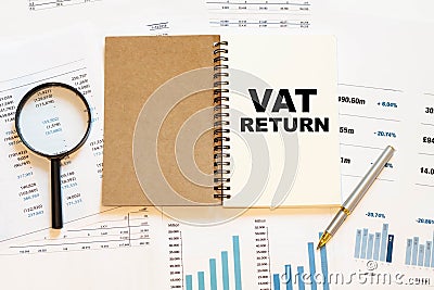 VAT RETURN - financial text on the first page of a notebook, against a background of numbers and charts Stock Photo