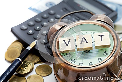 VAT word on Alarm clock and stacks coins Stock Photo