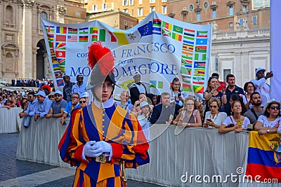 A portrait of a swiss guard in Vatican city, crowd of people in the main square waiting for the holy mass on sunday with Pope Editorial Stock Photo