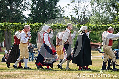 Vaxjo, Sweden, June 2023: People gathered around Maypole during Swedish Midsommar festival in traditional dressing Editorial Stock Photo