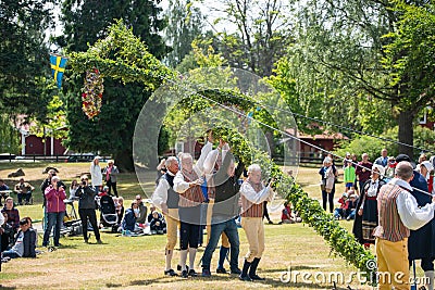 Vaxjo, Sweden, June 2023: People gathered around Maypole during Swedish Midsommar festival in traditional dressing Editorial Stock Photo