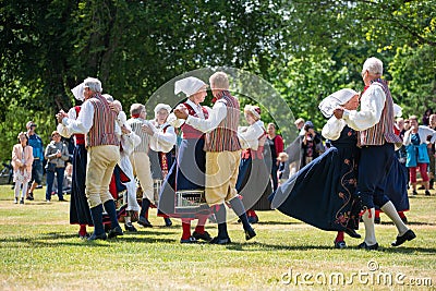 Vaxjo, Sweden, June 2023: People gathered around Maypole during Swedish Midsommar festival in traditional dressing Editorial Stock Photo