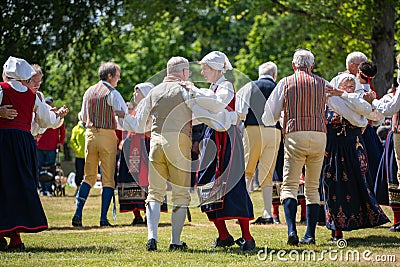 Vaxjo, Sweden, June 2023: People gathered around Maypole during Swedish Midsommar festival in traditional dressing Editorial Stock Photo