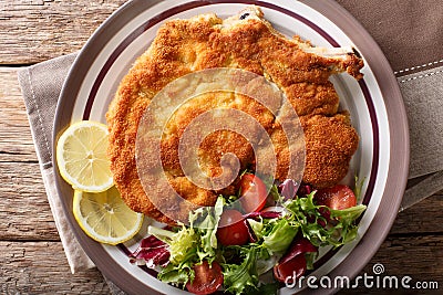 Veal milanese cotoletta alla milanese with lemon and fresh veg Stock Photo