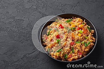 Veg Schezwan Fried Rice in black bowl at dark slate background. indo-chinese cuisine dish Stock Photo