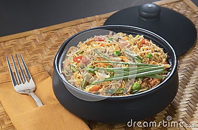 veg schezwan fried rice black bowl Stock Photo