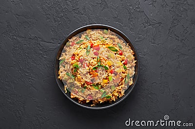 Veg Schezwan Fried Rice in black bowl at dark slate background. indo-chinese cuisine dish Stock Photo