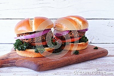 Vegan bean and sweet potato burgers with kale against a white wood background Stock Photo
