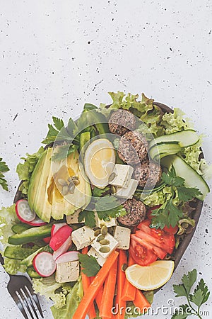 Vegan buddha bowl salad with vegetables, tofu, black beans meatballs and avocado, vertical. Healthy vegan food concept. Stock Photo