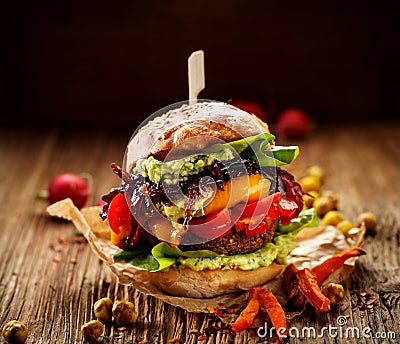 Vegan burger, carrot burger, homemade burger with carrot cutlet, grilled bell pepper, cherry tomatoes, red onion chutney, lettuce, Stock Photo