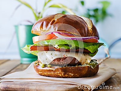 Vegan cheese burger on pretzal bun and meatless bacon Stock Photo