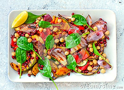 Mediterranean vegan chickpea salad with roasted pumpkins and pomegranate seeds Stock Photo