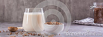 Vegan dairy-free buckwheat milk in a glass and cereals in a bowl on the table web banner Stock Photo