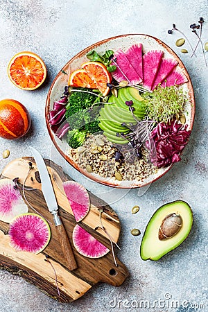 Vegan, detox Buddha bowl with quinoa, micro greens, avocado, blood orange, broccoli, watermelon radish, alfalfa seed sprouts. Stock Photo