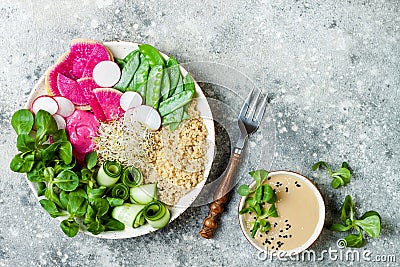 Vegan, detox Buddha bowl recipe with quinoa, snow peas, cucumber, watermelon radish, beet hummus, alfalfa seed sprouts. Stock Photo