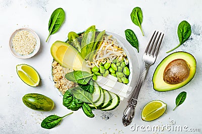 Vegan, detox green Buddha bowl recipe with quinoa, avocado, cucumber, spinach, tomatoes, mung bean sprouts, edamame beans, daikon Stock Photo