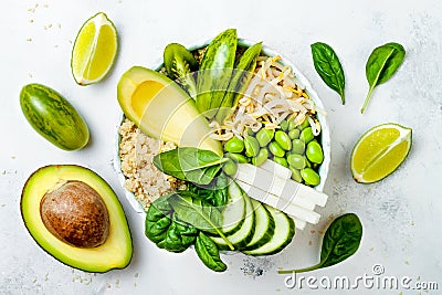 Vegan, detox green Buddha bowl recipe with quinoa, cucumber, broccoli, asparagus and sweet peas. Stock Photo