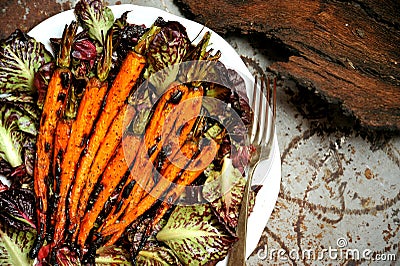 Vegan food with grilled carrots and bitter salad Stock Photo