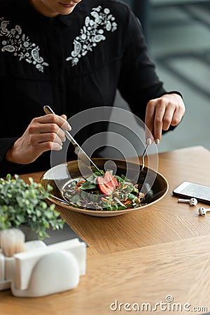 Vegan girl dines in a restaurant. Vegetable veggie salad garnished with fresh strawberries. Stock Photo